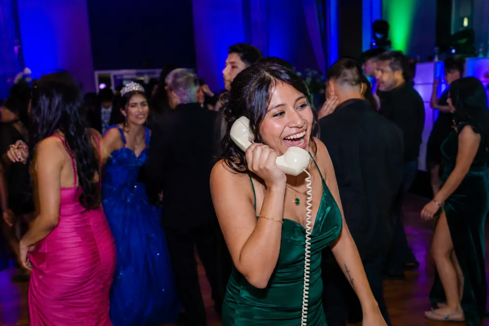 A guest shares a happy moment with the handset beside a colorful dance floor.